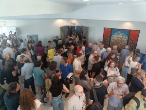 Ομιλητής σε εκδήλωση με ακουστικά και μικρόφωνο, μπροστά σε ακροατήριο