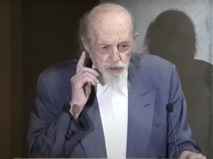 Ο κ. Τάσιος κατά την ομιλία του, με εικόνα του σε δεξιά θέση