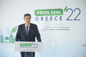 Ο Θόδωρος Σκυλακάκης σε συνέδριο, μιλάει και υπάρχει εικόνα με το πρόσωπό του